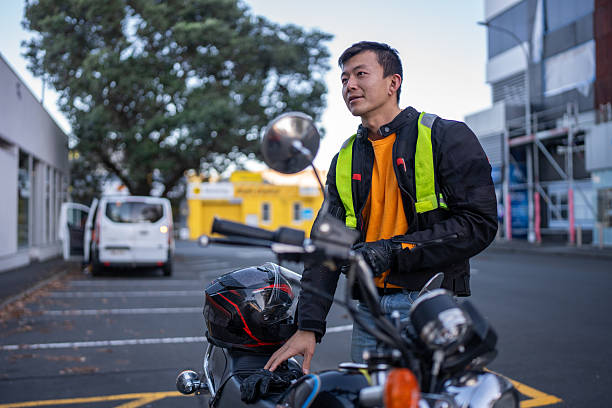 istock Man Standing Beside Motorcycle in Urban Car Park 2214657876