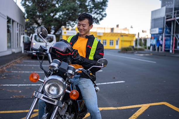 istock Man Sitting on Motorcycle Holding Helmet and Smiling 2214657878