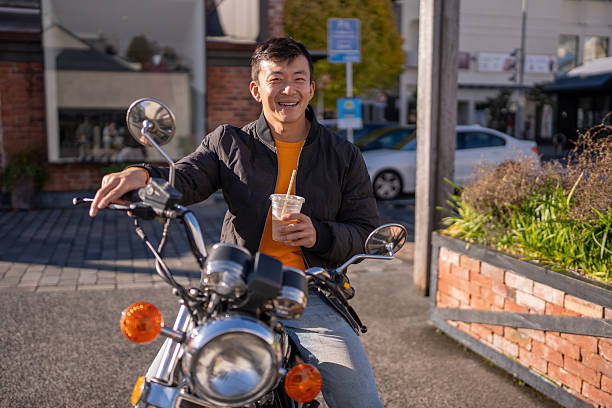 istock Man Sitting on Motorcycle with Iced Coffee 2214658040