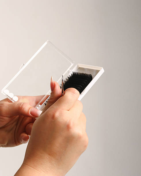 Close up of tweezer with bunch of fake lashes for eyelash extensions. Tools for the lashmaker. Space for text Close up of tweezer with bunch of fake lashes for eyelash extensions. Tools for the lashmaker. Copy space for text clump eyelashes stock pictures, royalty-free photos & images