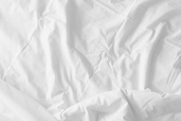 istock Abstract pattern of white crumpled bed sheet. White wrinkled fabric texture rippled surface. Close up image. 2214663562