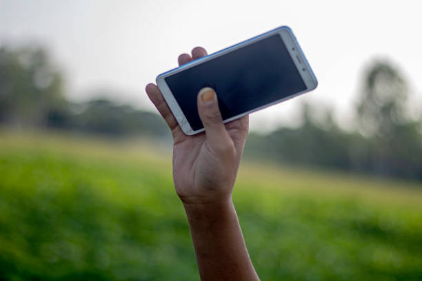 istock A Human hand holding a mobile phone and showing mobile screen and green background blur 2214663592