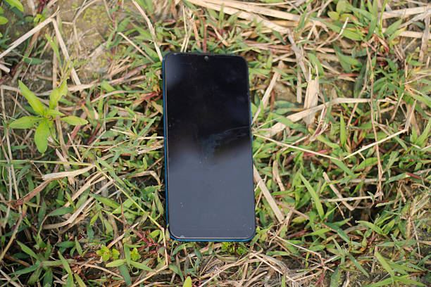 istock A mobile phone put on the grass ground and showing the black screen 2214664118
