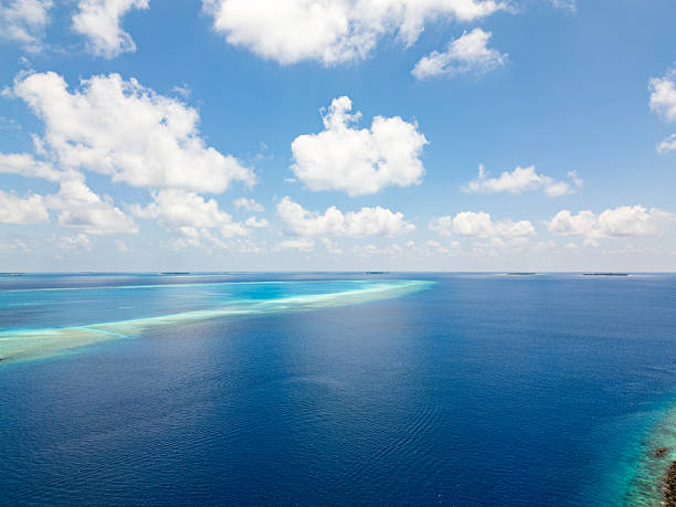 Aerial view of the Maldives islands with turquoise water and white clouds