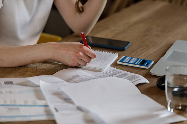istock Young woman planning her monthly budget and sorting out bills when managing finances 2214666263