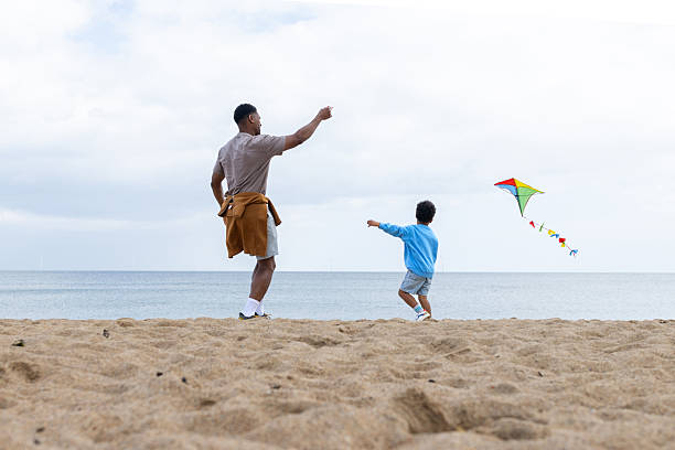istock Father and Son Playing with a Kite on the Beach 2214666802