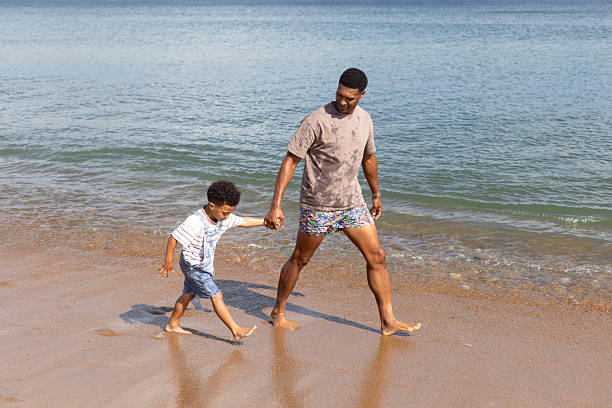 istock Father and Son Walking Along the Water's Edge 2214666833