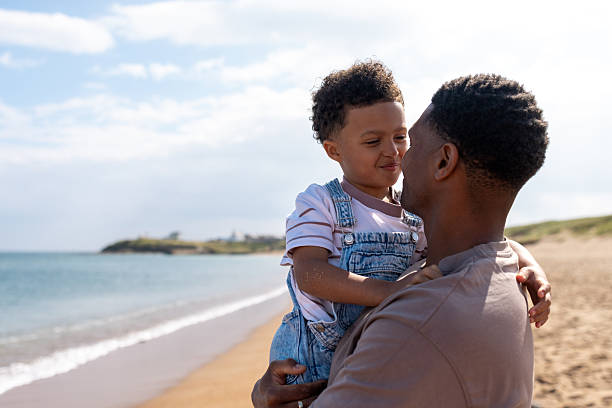 istock Loving Father Holding Son at the Beach 2214667059