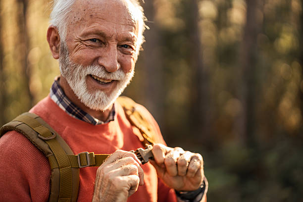 istock Smiling Elderly Man Adventure Hiking in Forest with Nature Background 2214669044