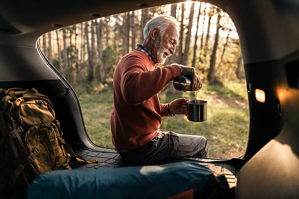 Senior Man Camping and Pouring Tea in Forest SUV