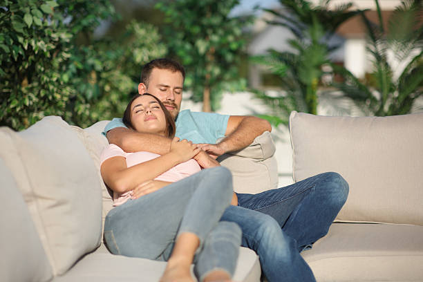 istock Couple sleeping sitting in a couch in a terrace 2214671193