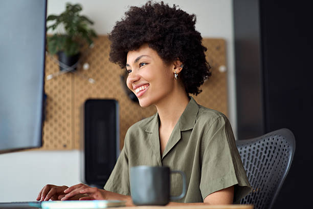 istock Happy young African American woman using computer working at work desk. 2214671371