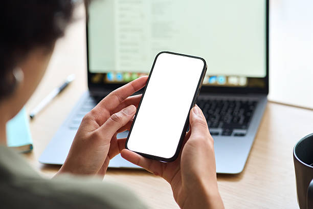istock Over shoulder view of Afro woman using mobile phone with mock up screen. 2214671391