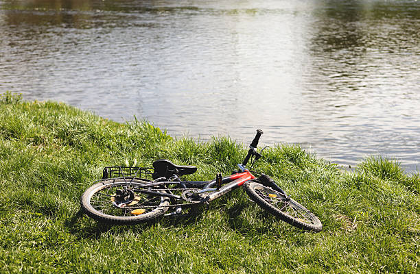 A child's bicycle lies on the grass