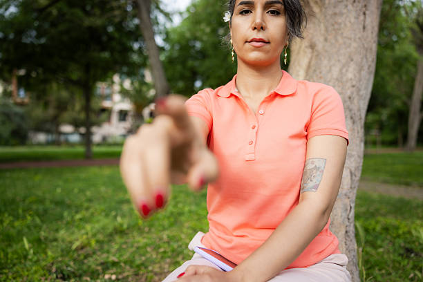 Pretty young lady is touching mobile phone screen in nature at public park.Istanbul - Turkey.
