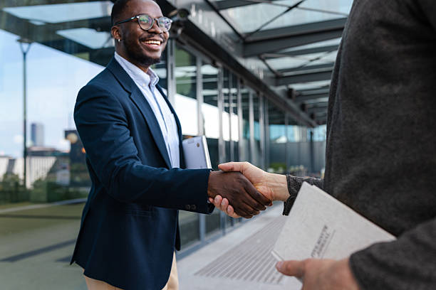 istock Confident professionals shaking hands outdoors 2214680505