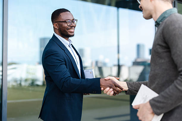 istock Two professionals shaking hands outdoors in a positive and friendly business interaction 2214680547
