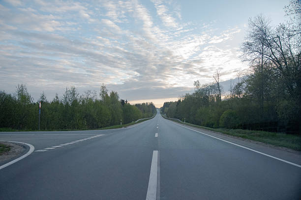 View of road passing through fields during sunset,