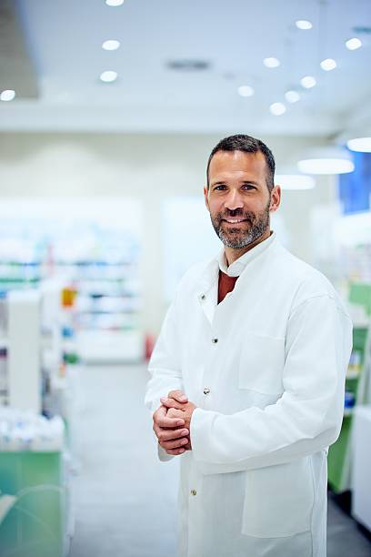 istock Friendly Male Pharmacist in Professional Attire Inside a Bright Retail Pharmacy 2214683727