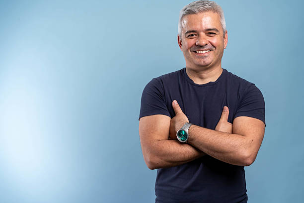 istock Mature man smiling at camera standing with arms crossed 2214685547