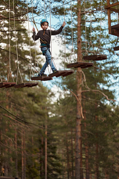 istock Little boy practicing in ropes course in adventure park 2214686564