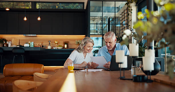 istock Reading, documents and laptop with old couple at home for social security benefits, annuity growth and retirement fund. Account balance, online banking and 401k withdrawal with people and profit 2214686874