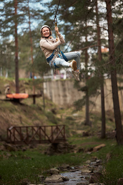 istock Happy woman having fun on zip line in the forest 2214687145
