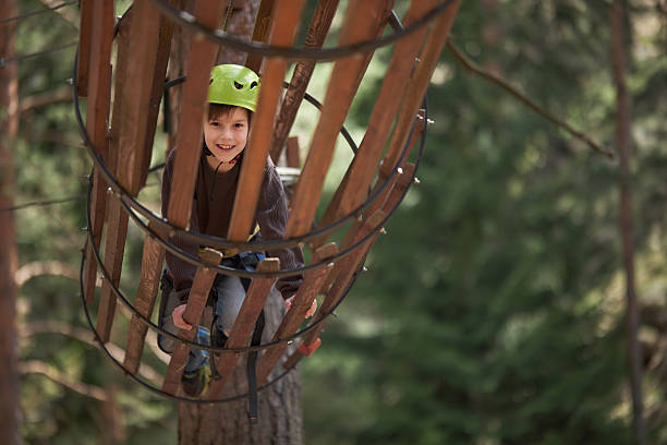 Cute happy boy having fun in adventure park