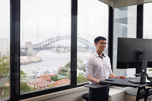 istock Employee working on a stand-up desk in corner office 2214689094