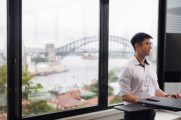 istock Employee working on a stand-up desk in corner office 2214689096