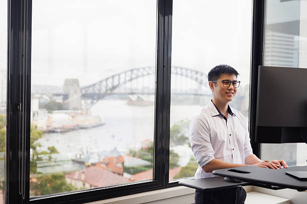istock Employee working on a stand-up desk in corner office 2214689196