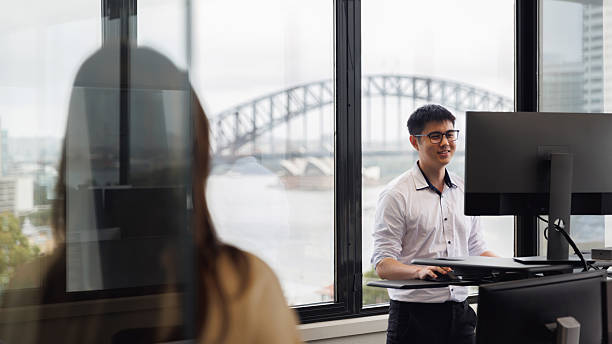 istock Employee working on a stand-up desk in corner office 2214689211