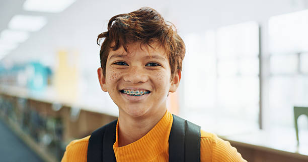 istock Portrait, knowledge and boy with braces, student and confidence with smile, pride and learning academy. Face, happy kid and childhood with backpack, studying opportunity and campus with education 2214689810