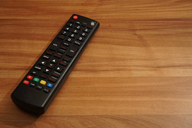 TV remote on brown wooden table