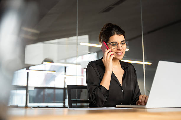 istock Indian professional businesswoman talking with business client, using telephone and pc computer for work Young female manager executive woman working on laptop, having phone call in corporate office 2214695251