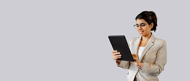 istock Focused latin or arab office hr manager woman working holding touchscreen tab computer isolated. Young indian female entrepreneur, financial bank manager using tablet app for work. Banner, copy space 2214695289