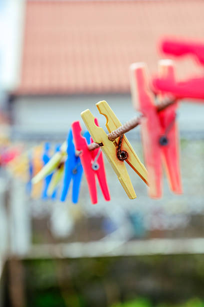 istock Colorful Plastic Clothespins Hanging on a Clothesline. Illustrates everyday laundry tasks and vibrant household items. 2214696029