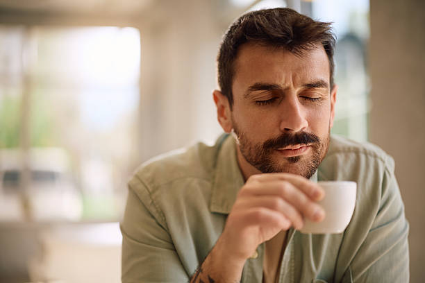 istock Man with eyes closed enjoying in a cup of coffee. 2214697446