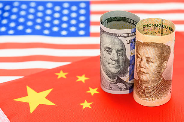 istock Trade war, reciprocal tariffs, economic sanctions, China-US trade relations : US dollars and Chinese yuan wrapped together against the backdrop of their national flags. US-China currency competition. 2214699269