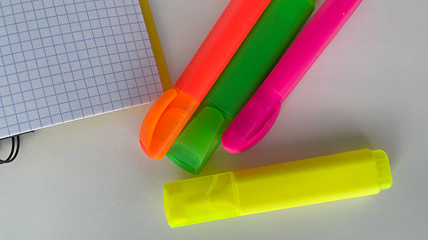 istock Bright neon highlighters and a squared grid notebook create a vibrant and organized workspace. Perfect for back to school, studying, office, or creative projects. This image is ideal for educational, productivity, and stationery-themed designs. 2214699503