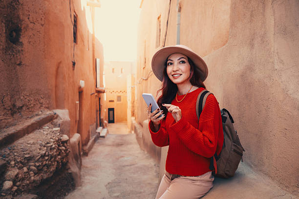 istock Young woman tourist using smartphone while exploring ancient Moroccan city, famous for its earthen architecture 2214699531