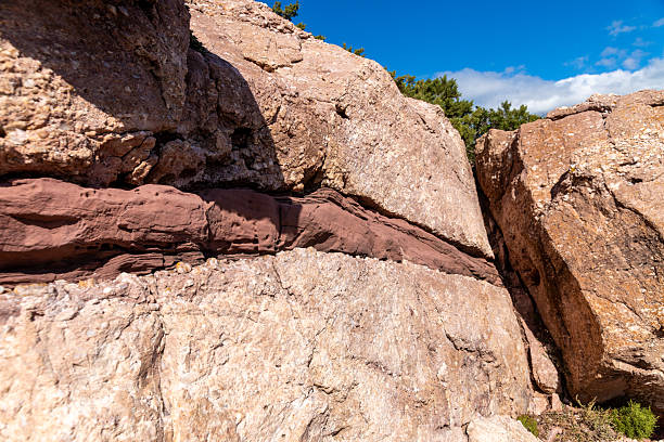 istock Layered Rock Formations with Reddish Sediment Line 2214699874