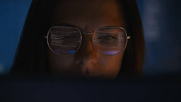 istock Female scientist working on a computer. Lines of code and calculations reflecting in eyeglasses. Medical science research 2214702529