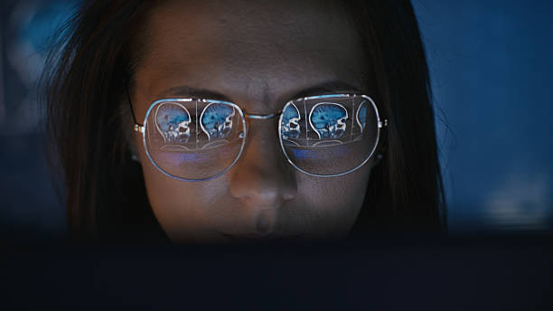 istock Female scientist working on a computer. Results of a human MRI scan on the computer screen reflecting in eyeglasses. Medical science research 2214702619