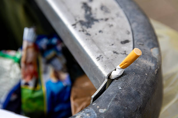 istock Cigarette stubbed on edge of public trash bin 2214704864