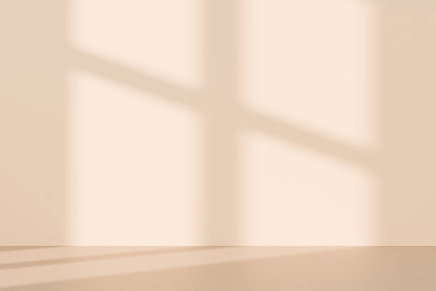 istock 3D beige studio room with a window shadow on the wall. Sunlight moves across the empty room. Background for product display, with space for text. 2214706089