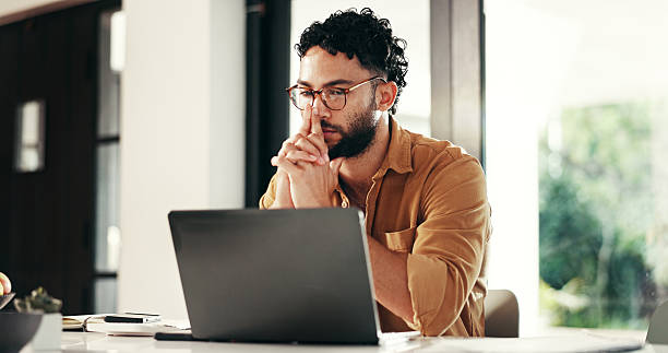 istock Laptop, thinking and man reading in home office for remote work, planning or journalist with story idea. Computer, creative freelancer and inspiration for article, problem solving or insight for news 2214707266