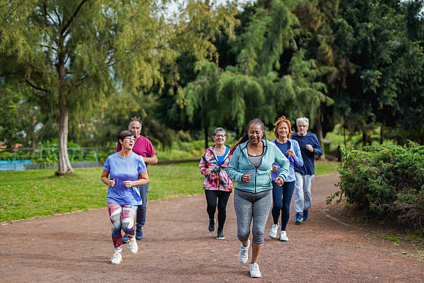 istock Happy senior people doing running workout at city park during summer time - Joyful elderly, sport and healthy elderly lifestyle concept - Soft focus on african woman 2214710152