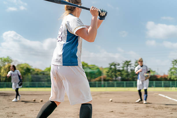 istock Female Softball Players Practicing on a Sunny Field in a Suburban Setting 2214715192