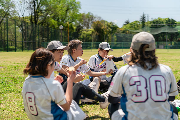 istock Female Softball Team Enjoying a Break During Practice in Tokyo Suburbs 2214715249